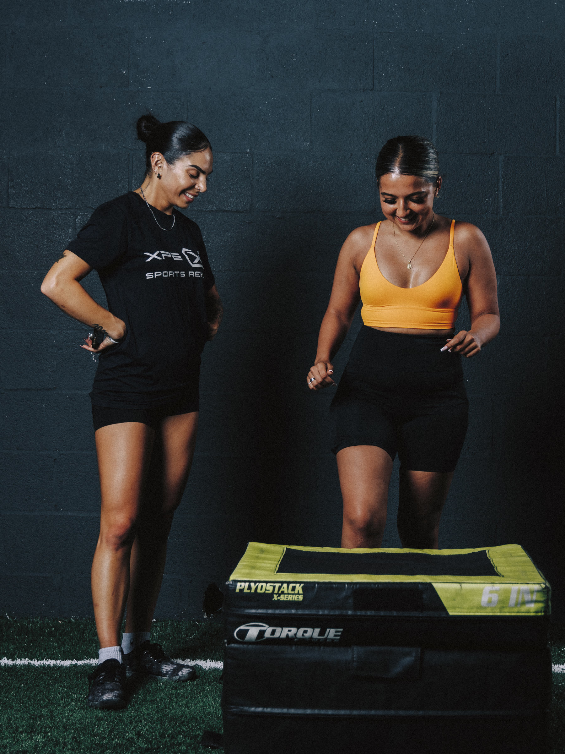 Nicole coaching an athlete stepping onto a plyo box.